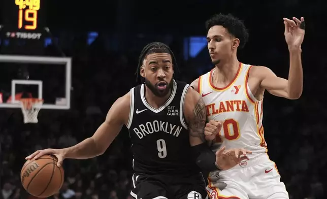 Atlanta Hawks' Zaccharie Risacher (10) defends Brooklyn Nets' Ziaire Williams (8) during the second half of an NBA basketball game Thursday, April 10, 2025, in New York. (AP Photo/Frank Franklin II)