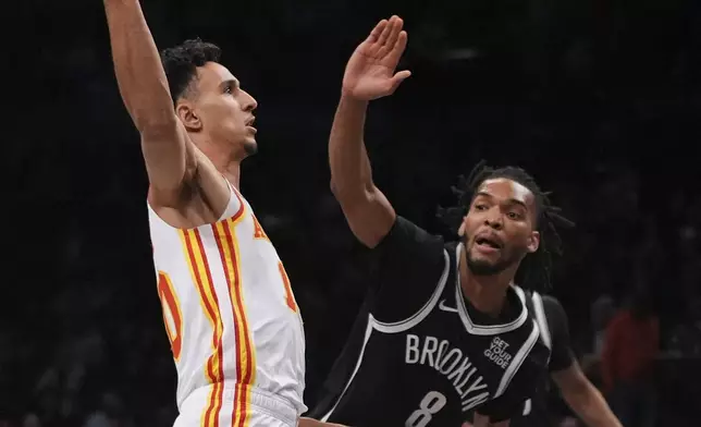 Atlanta Hawks' Zaccharie Risacher (10) drives past Brooklyn Nets' Ziaire Williams (8) during the first half of an NBA basketball game Thursday, April 10, 2025, in New York. (AP Photo/Frank Franklin II)