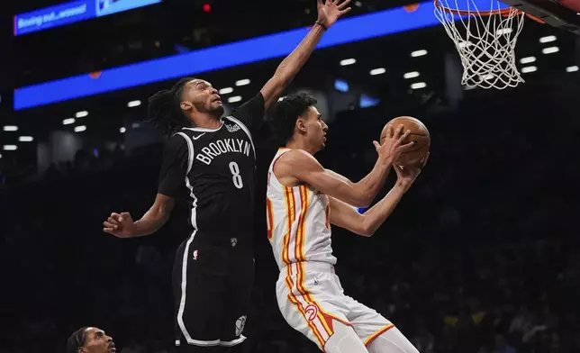 Atlanta Hawks' Zaccharie Risacher, right, drives past Brooklyn Nets' Ziaire Williams, center, during the first half of an NBA basketball game Thursday, April 10, 2025, in New York. (AP Photo/Frank Franklin II)