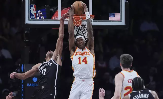Brooklyn Nets' Tosan Evbuomwan (12) defends a shot by Atlanta Hawks' Terance Mann (14) during the second half of an NBA basketball game Thursday, April 10, 2025, in New York. (AP Photo/Frank Franklin II)