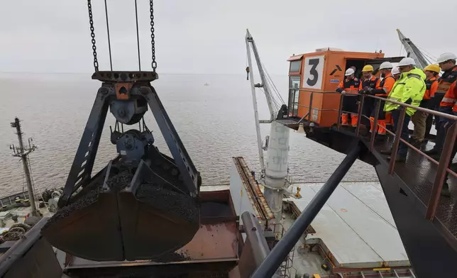 Britain's Business, Energy and Industrial Strategy Secretary Jonathan Reynolds, second from left, observes as coking coal is unloaded at Immingham Port, at Immingham Port, northern England, Tuesday, April 15, 2025. (Darren Staples/Pool Photo via AP)