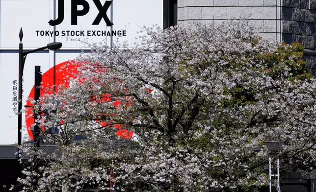 Cherry blossoms bloom across a street from the Tokyo Stock Exchange building in Tokyo, Wednesday, April 9, 2025. (AP Photo/Hiro Komae)