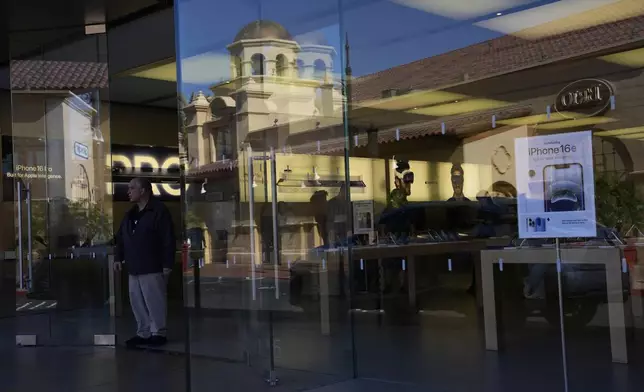 People shop in an Apple store Tuesday, April 8, 2025, in Las Vegas. (AP Photo/John Locher)