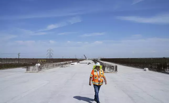 Eduardo Reyes, senior transportation engineer with the California High-Speed Rail Authority, walks through the Hanford Viaduct construction site, Tuesday, April 15, 2025, in Kings County, Calif. (AP Photo/Godofredo A. Vásquez)