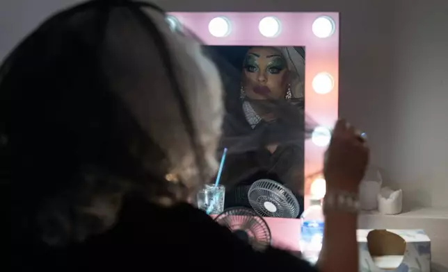 Drag queen Valerie DeVille adjusts her veil before performing in a "blaze and praise" drag brunch at Bar Carlo on Sunday, April 20, 2025, in Portland, Ore. (AP Photo/Jenny Kane)