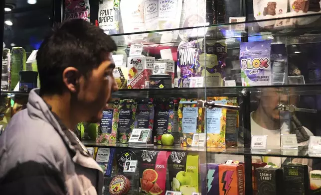 Kobe Norell shops for products at Have a Heart cannabis dispensary Sunday, April 20, 2025, in Seattle. (AP Photo/Lindsey Wasson)