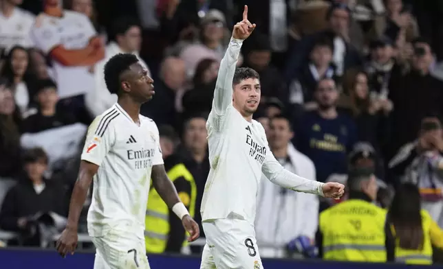 Real Madrid's Federico Valverde celebrates scoring his side's first goal next to Vinicius Junior during the Spanish La Liga soccer match between Real Madrid and Athletic Bilbao at the Santiago Bernabeu stadium in Madrid, Sunday, April 20, 2025. (AP Photo/Manu Fernandez)