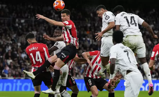 Real Madrid's Jude Bellingham, top second from right, heads the ball on shot during the Spanish La Liga soccer match between Real Madrid and Athletic Bilbao at the Santiago Bernabeu stadium in Madrid, Sunday, April 20, 2025. (AP Photo/Manu Fernandez)