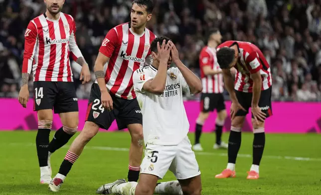 Real Madrid's Jude Bellingham, front, reacts after missing a chance to score during the Spanish La Liga soccer match between Real Madrid and Athletic Bilbao at the Santiago Bernabeu stadium in Madrid, Sunday, April 20, 2025. (AP Photo/Manu Fernandez)