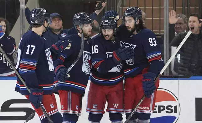 New York Rangers' Vincent Trocheck (16) celebrates with teammates Will Borgen (17), Mika Zibanejad (93) and Zac Jones (6) after scoring a goal during the first period of an NHL hockey game against the Philadelphia Flyers Wednesday, April 9, 2025, in New York. (AP Photo/Frank Franklin II)