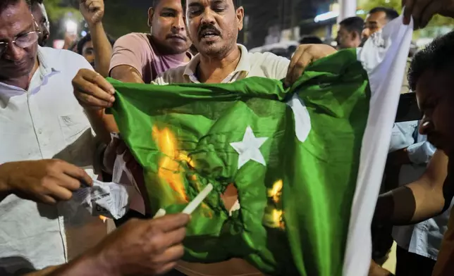 People burn a Pakistani flag in protest against the killing of tourists by militants a day after militants indiscriminately opened fire on tourists near Pahalgam in Indian controlled Kashmir, in Guwahati, India, Wednesday, April 23, 2025. (AP Photo/Anupam Nath)