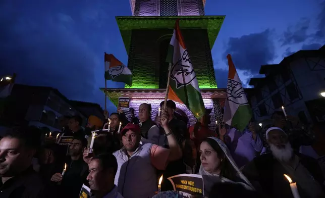 Members of Indian youth congress party hold candles and their party flags during a candlelight protest in Srinagar, Indian controlled Kashmir, Wednesday, April 23, 2025, a day after an attack killed at least 26 people, most of them tourists. (AP Photo/Mukhtar Khan)