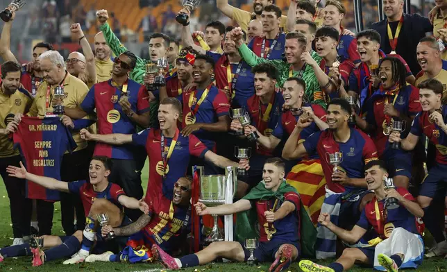 Barcelona players celebrate with the trophy after winning the Spanish Copa del Rey final soccer match between Barcelona and Real Madrid at Estadio de La Cartuja stadium in Seville, Spain, Sunday, April 27, 2025. (AP Photo/Joan Monfort)