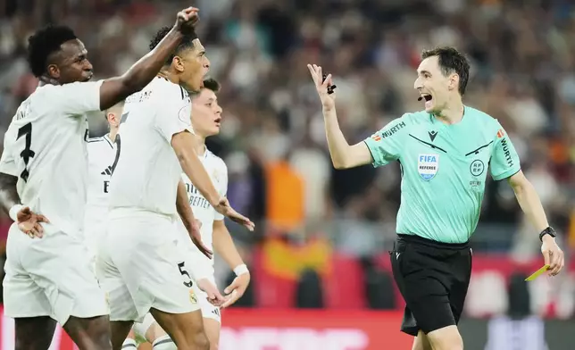 Real Madrid players argue with referee Ricardo De Burgos Bengoetxea, right, during the Spanish Copa del Rey final soccer match between Barcelona and Real Madrid at Estadio de La Cartuja stadium in Seville, Spain, Saturday, April 26, 2025. (AP Photo/Jose Breton)