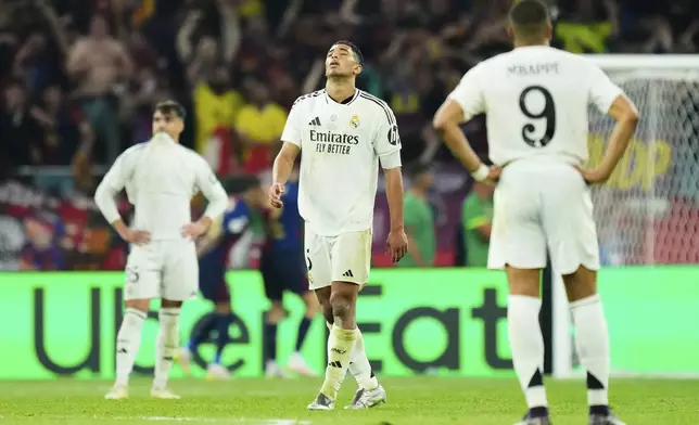 Real Madrid's Jude Bellingham, centre, reacts disappointed after the Spanish Copa del Rey final soccer match between Barcelona and Real Madrid at Estadio de La Cartuja stadium in Seville, Spain, Saturday, April 26, 2025. (AP Photo/Jose Breton)