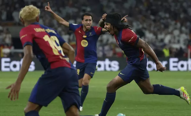 Barcelona's Jules Kounde, right, celebrates after scoring his side's third goal during the Spanish Copa del Rey final soccer match between Barcelona and Real Madrid at Estadio de La Cartuja stadium in Seville, Spain, Sunday, April 27, 2025. (AP Photo/Joan Monfort)