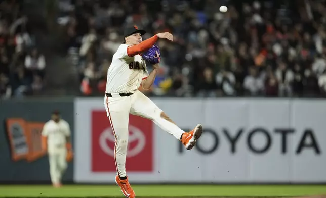 San Francisco Giants shortstop Willy Adames throws to first for an out on Milwaukee Brewers' Caleb Durbin during the seventh inning of a baseball game Monday, April 21, 2025, in San Francisco. (AP Photo/Godofredo A. Vásquez)