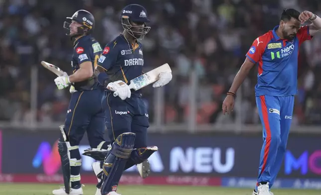 Gujarat Titans' Jos Butler and Sherfane Rutherford run between the wickets to score during the Indian Premier League cricket match between Gujarat Titans and Delhi Capitals at Narendra Modi Stadium in Ahmedabad, India, Saturday, April 19, 2025. (AP Photo/Ajit Solanki)