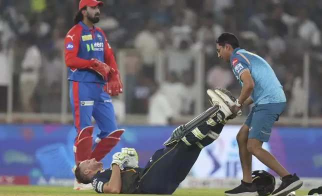 Gujarat Titans' Jos Butler gets medical attention after a muscle pain during the Indian Premier League cricket match between Gujarat Titans and Delhi Capitals at Narendra Modi Stadium in Ahmedabad, India, Saturday, April 19, 2025. (AP Photo/Ajit Solanki)