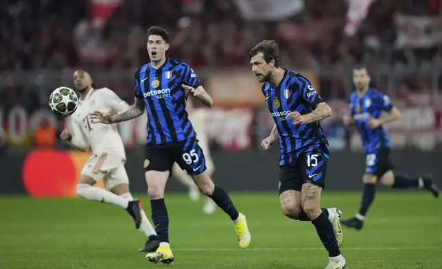 Inter Milan's Francesco Acerbi, front right, and Inter Milan's Alessandro Bastoni, left, run for the ball during the Champions League quarterfinals first leg soccer match between FC Bayern Munich and Inter Milan, at the Allianz Arena in Munich, Germany, Tuesday, April 8, 2025. (AP Photo/Matthias Schrader)