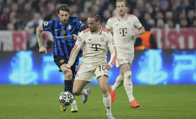 Bayern's Leroy Sane, front, duels for the ball with Inter Milan's Francesco Acerbi, left, during the Champions League quarterfinals first leg soccer match between FC Bayern Munich and Inter Milan, at the Allianz Arena in Munich, Germany, Tuesday, April 8, 2025. (AP Photo/Matthias Schrader)