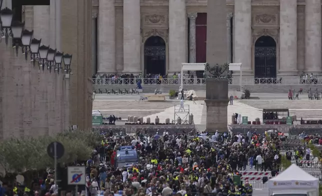 People line up along Via della Conciliazione avenue to view Pope Francis lying in state inside St. Peter's Basilica, seen in the background, at the Vatican, Thursday, April 24, 2025. (AP Photo/Andrew Medichini)