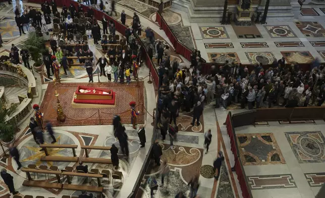 Faithful pay their respects to Pope Francis lying in state inside St. Peter's Basilica at the Vatican, Thursday, April 24, 2025. (AP Photo/Alessandra Tarantino)