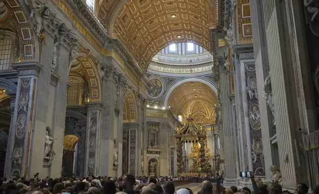 Faithful gather to pay their respects to Pope Francis inside St. Peter's Basilica at the Vatican, Wednesday, April 23, 2025, where his body will lie in state for three days. (AP Photo/Alessandra Tarantino)