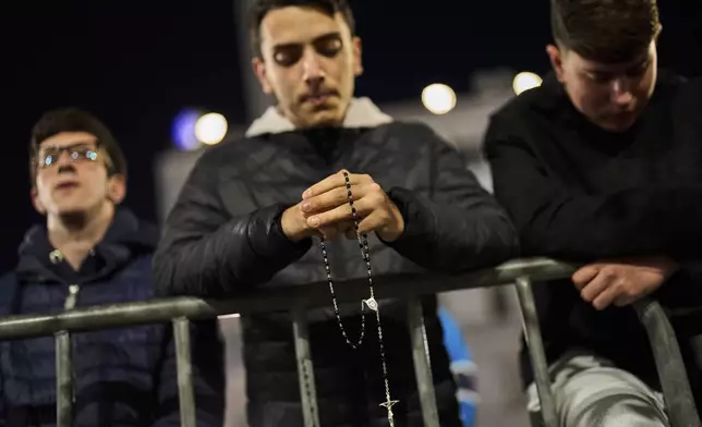 Men attend a rosary prayer for the late Pope Francis, at St. Mary Major Basilica in Rome, Wednesday, April 23, 2025. (AP Photo/Bernat Armangue)