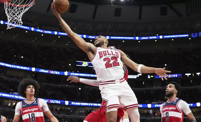 Chicago Bulls forward Talen Horton-Tucker (22) drives to the basket past Washington Wizards forward Alex Sarr, behind, during the second half of an NBA basketball game in Chicago, Friday, April 11, 2025. (AP Photo/Nam Y. Huh)