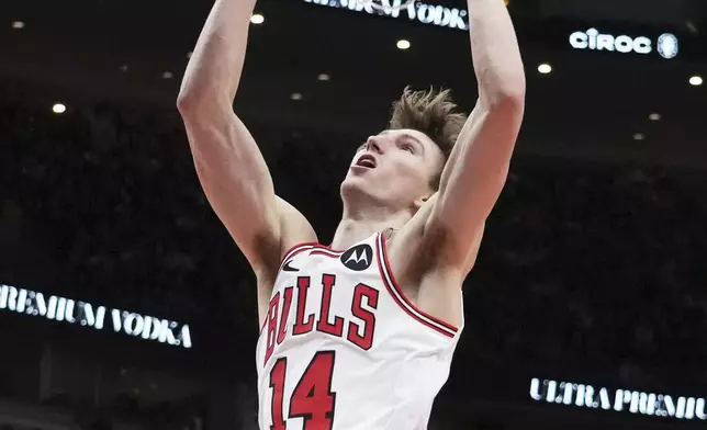 Chicago Bulls forward Matas Buzelis hangs from the rim after dunking during the second half of an NBA basketball game against the Washington Wizards in Chicago, Friday, April 11, 2025. (AP Photo/Nam Y. Huh)