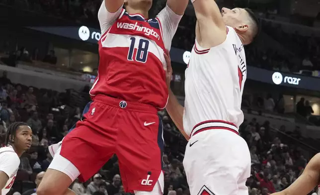 Washington Wizards forward Kyshawn George (18) shoots against Chicago Bulls center Nikola Vucevic, right, during the first half of an NBA basketball game in Chicago, Friday, April 11, 2025. (AP Photo/Nam Y. Huh)