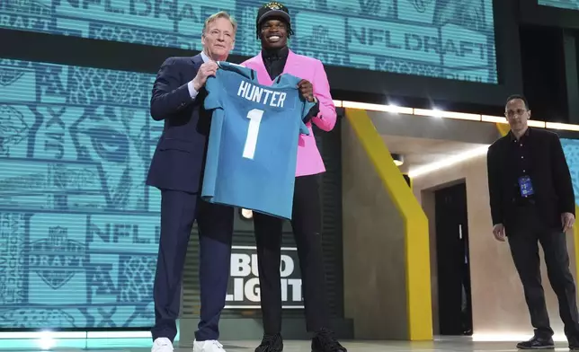 Colorado wide receiver Travis Hunter, right, poses with NFL Commissioner Roger Goodell after being chosen by the Jacksonville Jaguars with the second overall pick during the first round of the NFL football draft, Thursday, April 24, 2025, in Green Bay, Wis. (AP Photo/Jeff Roberson)