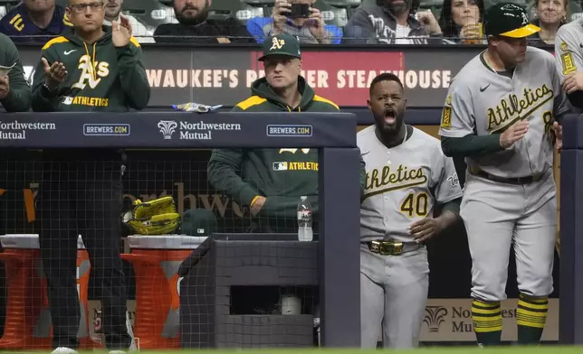 Athletics' Luis Severino (40) celebrates in the dugout after a baseball game against the Milwaukee Brewers, Saturday, April 19, 2025, in Milwaukee. (AP Photo/Aaron Gash)