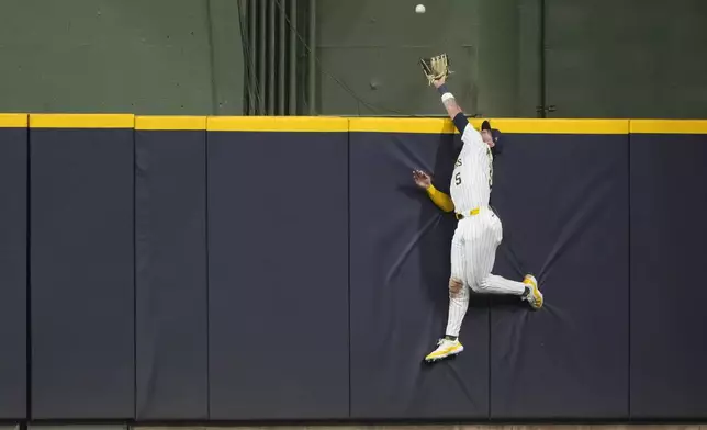 Milwaukee Brewers' Garrett Mitchell is unable to catch a home run hit by Athletics' Brent Rooker during the sixth inning of a baseball game Saturday, April 19, 2025, in Milwaukee. (AP Photo/Aaron Gash)