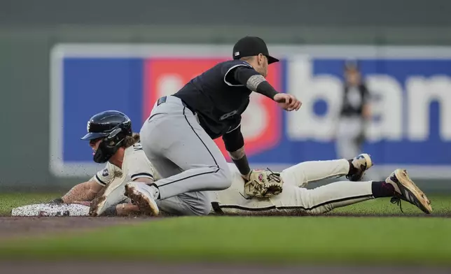 Minnesota Twins' Luke Keaschall (15) beats the tag by Chicago White Sox shortstop Jacob Amaya (8) to steal second base during the third inning of a baseball game Tuesday, April 22, 2025, in Minneapolis. (AP Photo/Abbie Parr)