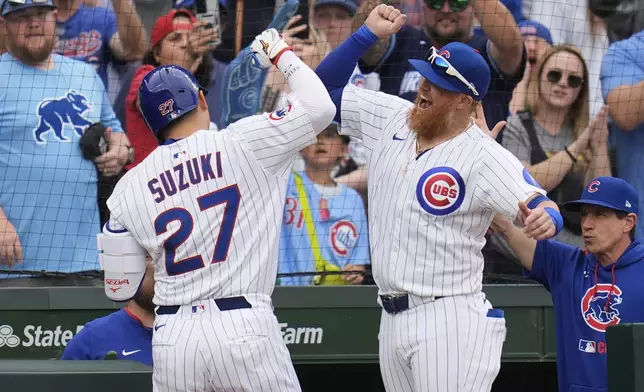 Chicago Cubs' Justin Turner (3), right, high-fives designated hitter Seiya Suzuki (27) after Suzuki hit a home run during the eighth inning of a baseball game against the Arizona Diamondbacks, Friday, April 18, 2025, in Chicago. (AP Photo/Erin Hooley)