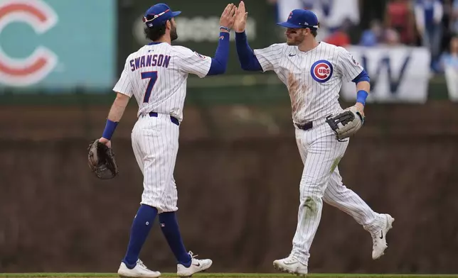 Chicago Cubs' Dansby Swanson (7) and Ian Happ, right, celebrate after their win over the Arizona Diamondbacks in a baseball game Friday, April 18, 2025, in Chicago. (AP Photo/Erin Hooley)