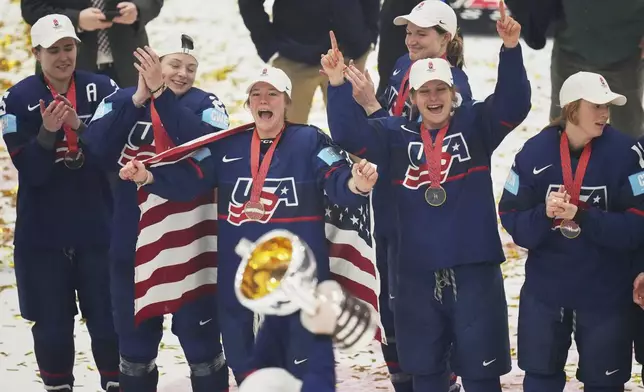 United states players celebrate with a trophy after the gold medal match between Canada and United States at the Women's Ice Hockey Championships in Ceske Budejovice, Czech Republic, Sunday, April 20, 2025. (AP Photo/Petr David Josek)