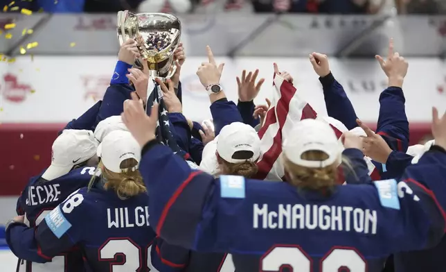 United states players celebrate with a trophy after the gold medal match between Canada and United States at the Women's Ice Hockey Championships in Ceske Budejovice, Czech Republic, Sunday, April 20, 2025. (AP Photo/Petr David Josek)