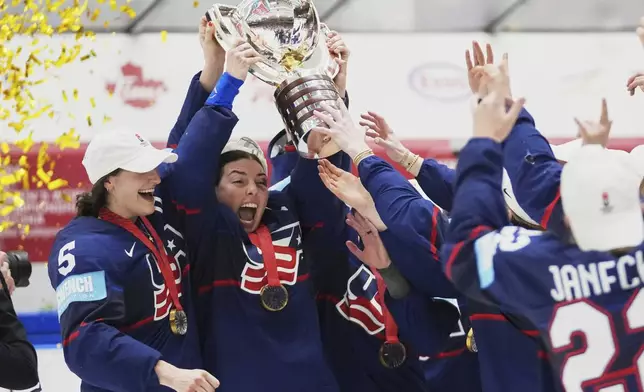 United states players celebrate with a trophy after the gold medal match between Canada and United States at the Women's Ice Hockey Championships in Ceske Budejovice, Czech Republic, Sunday, April 20, 2025. (AP Photo/Petr David Josek)