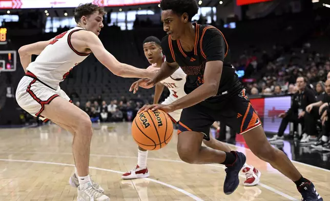 Chatsworth High School basketball player Alijah Arenas, right, is defended by a Jesuit player in the second half of a boys CIF State Division II championship basketball game in Sacramento, Saturday, March 15, 2025. (Keith Birmingham/The Orange County Register via AP)