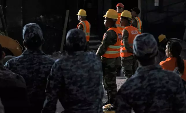 Rescue workers stand by as they take turns searching for survivors at the Jet Set nightclub after its roof collapsed two nights ago during a merengue concert in Santo Domingo, Dominican Republic, Wednesday, April 9, 2025. (AP Photo/Ricardo Hernandez)