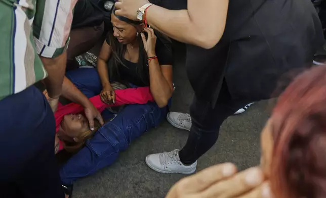 Relatives cry while waiting for news of loved ones outside the Jet Set nightclub after its roof collapsed during a merengue concert in Santo Domingo, Dominican Republic, Tuesday, April 8, 2025. (AP Photo/Eddy Vittini)