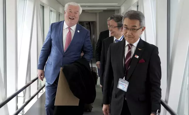 U.S. Ambassador to Japan George Glass, left, is escorted by Victor Osumi, right, president of Japan Operations of Delta, upon his arrival at Haneda Airport in Tokyo Friday, April 18, 2025. (Kazuhiro Nogi/Pool Photo via AP)