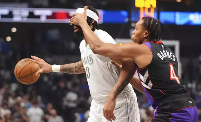 Dallas Mavericks forward Anthony Davis (3) has his face covered by Toronto Raptors' Scottie Barnes (4) as he handles the ball in the first half of an NBA basketball game in Dallas, Friday, April 11, 2025. (AP Photo/LM Otero)