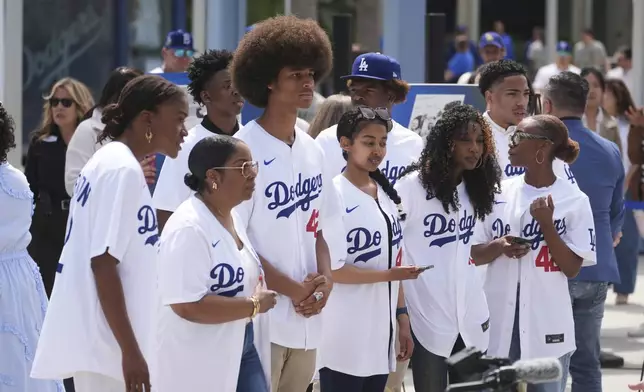 People gather at Dodger Stadium to commemorate Jackie Robinson Day before a baseball game against the Colorado Rockies Tuesday, April 15, 2025, in Los Angeles. (AP Photo/Damian Dovarganes)