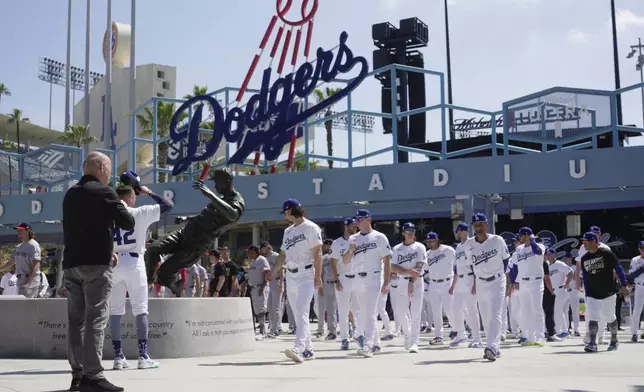 FILE - Los Angeles Dodgers and Washington Nationals team members arrive to celebrate Jackie Robinson Tribute Day before a baseball game at Dodger Stadium in Los Angeles, on Monday, April 15, 2024. (AP Photo/Damian Dovarganes, File)