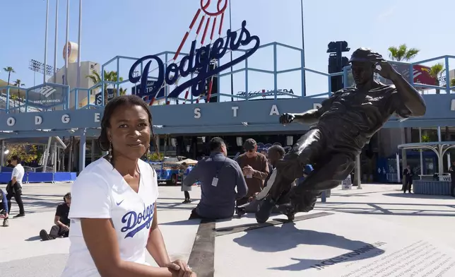 FILE - Ayo Robinson, the granddaughter of baseball great Jackie Robinson, pauses next to a sculpture of her grandfather on Jackie Robinson Day before a baseball game between the Los Angeles Dodgers and the Washington Nationals at Dodger Stadium in Los Angeles, Monday, April 15, 2024. (AP Photo/Damian Dovarganes, File)