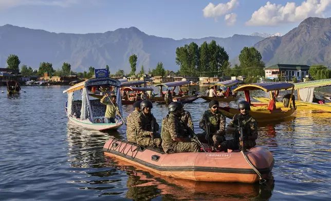 Paramilitary soldiers patrol on an inflatable boat as Indian tourists take boat rides on Dal Lake in Srinagar, Indian controlled Kashmir, Friday, April 25, 2025. (AP Photo/Dar Yasin)